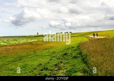 Blick auf Pilsum Leuchtturm in Ostfriesland mit Touristen zu Fuß Rund um den Deich und Fotografieren Stockfoto
