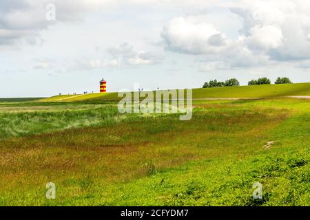 Blick auf Pilsum Leuchtturm in Ostfriesland mit Touristen zu Fuß Rund um den Deich und Fotografieren Stockfoto