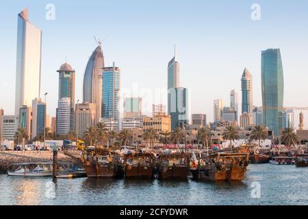 Traditionelle Holzdaus im Fischerhafen mit Skyline im Hintergrund. Kuwait Stockfoto