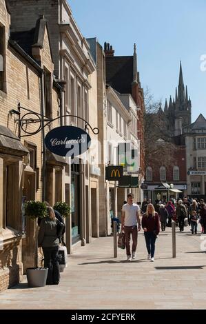 Geschäfte auf einer Straße in Peterborough mit der Kathedrale im Hintergrund, Cambridgeshire, England. Stockfoto