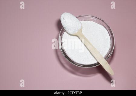 Kollagenpulver auf rosa Hintergrund. Natürliche Schönheit und Gesundheit Ergänzung für Haut, Knochen, Gelenke und Darm. Eiweiß Stockfoto