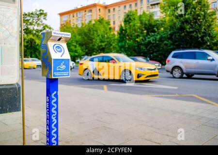 Moskau. Russland. 04. September 2020 EIN Gerät zur berührungslosen Händedesinfektion an einer Haltestelle des öffentlichen Verkehrs auf der Fahrbahn mit fahrenden Fahrzeugen. Modern Stockfoto