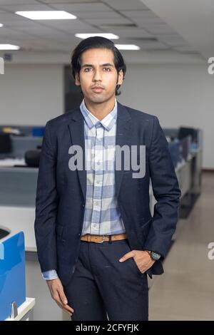 Porträt eines hübschen jungen indischen Geschäftsmann steht vor Corporate Office Hintergrund. Stockfoto