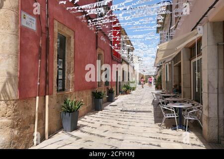 ALCUDIA, SPANIEN - 10. AUGUST 2019: Schmale Gasse Carrer De La Roca in der Altstadt von Alcudia, Mallorca, Spanien. Stockfoto