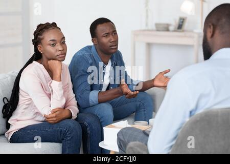 Emotionaler afrikanischer Mann, der sich über Probleme mit der Frau beim Paar beschwert Therapiesitzung Stockfoto