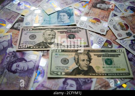 In dieser Abbildung ist eine Sammlung britischer fünf-, zehn- und zwanzig-Pfund-Sterling- und zwanzig- und fünfzig-Dollar-Banknoten zu sehen. Stockfoto