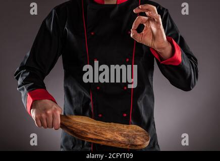 Nahaufnahme des Meisterkochs mit Holzschneidebrett. Konzept der Lebensmittelzubereitung, bereit für die Produktplatzierung. Stockfoto