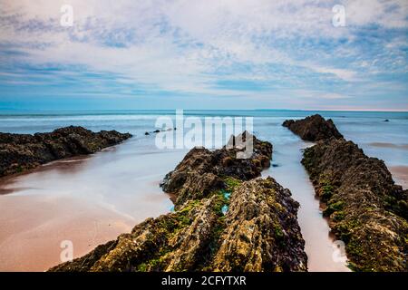 Blick in die Dämmerung auf Strata Rocks und Bristol Channel bei Sonnenuntergang von Croyde Bay, North Devon, England, Großbritannien. Stockfoto