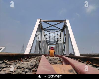 Mann an Eisenbahnschienen Eisenbrücke einzigartigen Winkel erschossen Stockfoto