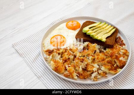 Leckere hausgemachte gebratene Hashbrowns und Eier auf einem Teller, Seitenansicht. Speicherplatz kopieren. Stockfoto