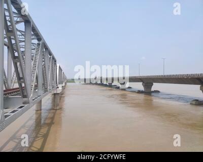 Eisenbahn und Straßenbrücke über fließenden Fluss in Tag Stockfoto