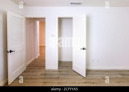 Türen in einem leeren Schlafzimmer, die zum Wohnzimmer und führen Ein Schrank Stockfoto