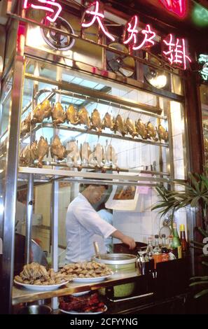 Hong Kong China Chinese Asians Kowloon, Restaurant Restaurants kochen Fenster kochen, Verkauf Nacht, Ente Huhn Essen, Mann Männer männlich, Neon-Zeichen Charakter Stockfoto