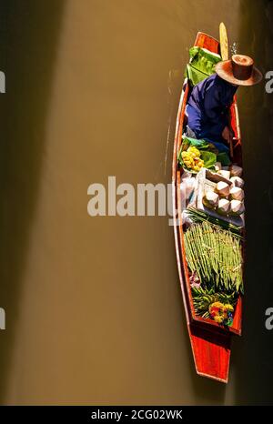 Thailändische Obstverkäufer mit traditionellen Hut in Holzboot mit Kokosnuss, Jack Obst und Banane, Damnoen Saduak schwimmenden Markt, Ratchaburi, Thailand. Stockfoto