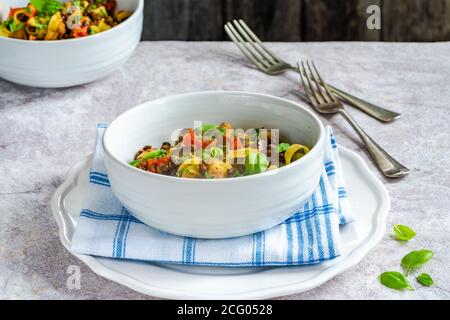 Linsen- und Auberginenragu mit Tagliatelle-Pasta und frischem Basilikum - gesundes vegetarisches Essen Stockfoto