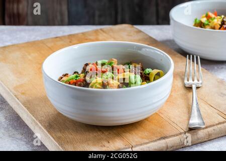 Linsen- und Auberginenragu mit Tagliatelle-Pasta und frischem Basilikum - gesundes vegetarisches Essen Stockfoto