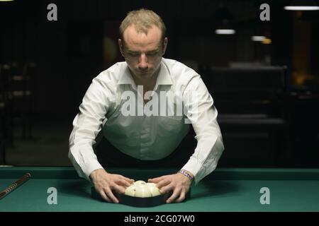 Billard spielen: Spieler, der Bälle für den Beginn des Spiels aufsetzt. Oktober 2018. Kiew, Ukraine Stockfoto