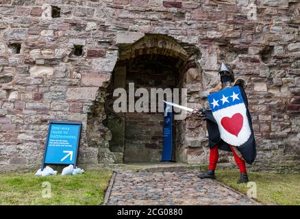 Mittelalterlicher Ritter mit Schwert, Hemet & Schild mit Gesichtsmaske und Einbahnschild, Tantallon Castle, East Lothian, Schottland, UK Stockfoto