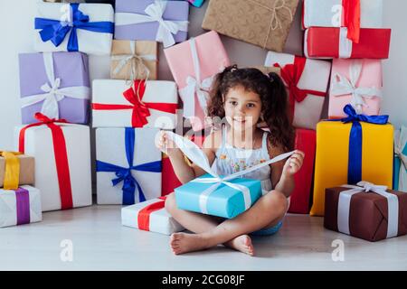 Schöne kleine lockige Mädchen mit Geschenken für Geburtstagsfeier Stockfoto