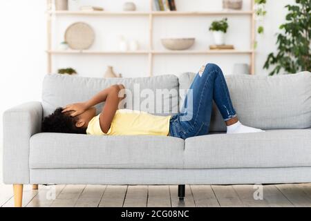 Frustriert Schwarz Mädchen Weinen Abdeckung Gesicht Liegend Auf Couch Drinnen Stockfoto