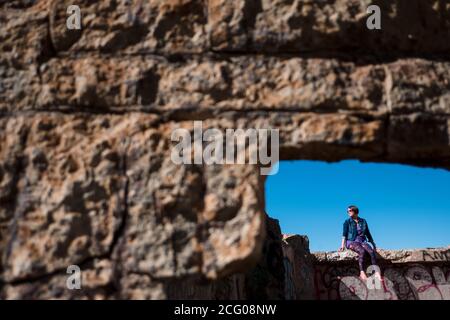 Frau, die an einer Wand in den sutro Bädern sitzt san francisco Stockfoto