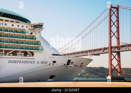 Lissabon, Portugal - September 2011: Nahaufnahme der Front des Kreuzfahrtschiffes Independence of the Seas mit der Hängebrücke 25 de Abril Stockfoto