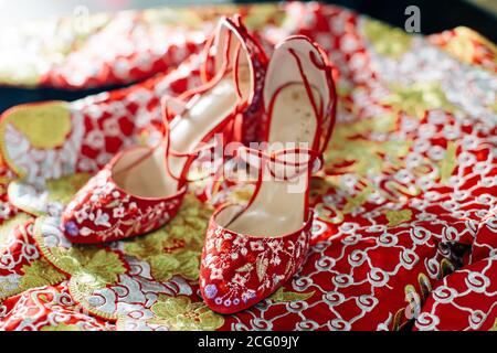 Nahaufnahme eines Paares roter Farbe chinesischen Hochzeit Schuhe mit aufwändigen orientalischen Mustern Stockfoto