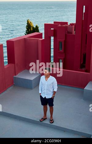 Junger lateinischer Mann meditativ in 'Muralla Roja' aus Calpe, Spanien Stockfoto
