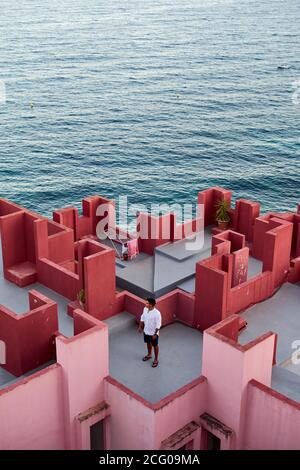 Junger lateinischer Mann meditativ in 'Muralla Roja' aus Calpe, Spanien Stockfoto