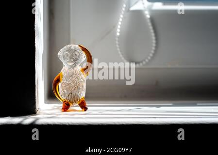 Glasmonkey Figur auf dem Fenster Stockfoto