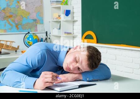 Gelangweilte und müde schlafende Schüler im Klassenzimmer. Demotivierte langweilige Studenten sitzen in einer Vorlesung in der Hochschule. Stockfoto