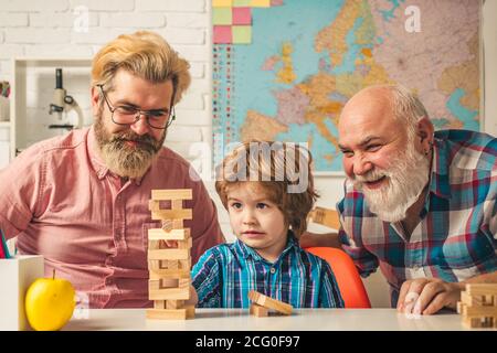 Freundschaft zwischen männlichen Generationen. Lachende Großeltern mit Sohn und Enkelkind erholsam verbringen Wochenende zu Hause. So Spielen Sie Jenga: Stockfoto