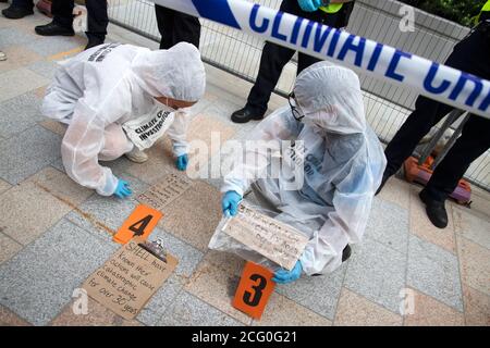 London, Großbritannien. September 2020. Extinction Rebellion Protestierende veranstalten eine Demonstration vor den Shell-Büros, Jubilee Gardens, London, 8. September 2020, die ein Ende der fossilen Energiegewinnung, des Ökozids und der Unterdrückung im globalen Süden fordert, gefolgt von einem reparationsmarsch vor dem Parlament. Demonstranten in Hazmat Anzüge schaffen einen Klima-Tatort außerhalb der Shell Büros von der Polizei beobachtet Kredit: Denise Laura Baker/Alamy Live News Stockfoto