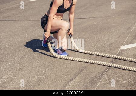 Fitness Menschen trainieren mit Kampfseilen. Frau Training mit Kampfseil Training trainieren Arme und Cardio für Cross-Fit-Übungen Stockfoto