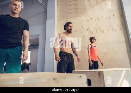 Männliche und weibliche Athleten tun, springt auf und Fitnessraum Stockfoto