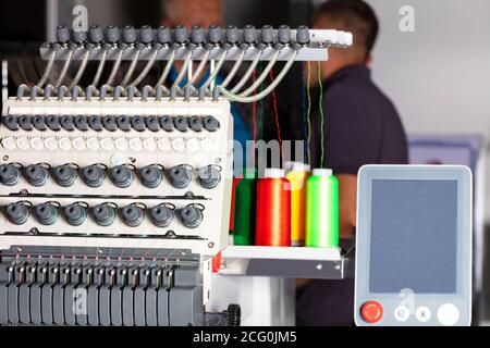 Industrielle Stickmaschine mit mehrfarbigen Fäden, Nahaufnahme. Stockfoto