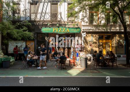 Pizzaliebhaber üben am Sonntag, den 23. August 2020, beim Essen im Freien vor der beliebten Prince Street Pizza im New Yorker Stadtteil Nolita soziale Distanz. (© Richard B. Levine) Stockfoto