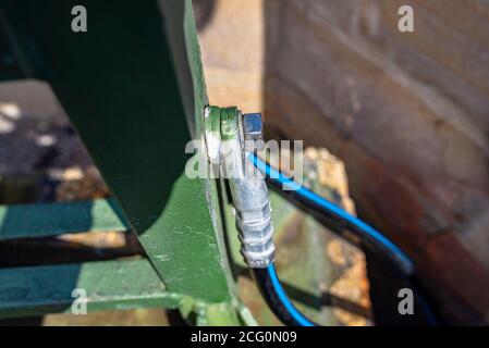 Ein Erdungskabel, das die Metallgeländer an der Eisenbahnbrücke verbindet. Stockfoto