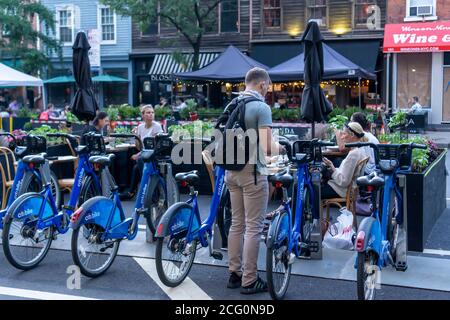 Essen im Freien in einem Restaurant in New York, getrennt durch eine CitiBike-Dockingstation am Mittwoch, 2. September 2020. Auch wenn das Essen im Freien jetzt erlaubt ist, werden Restaurants in der Stadt immer noch das Essen im Innenbereich verwehrt. (© Richard B. Levine) Stockfoto