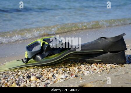 Schnorchelmaske und Flossen liegen an der Küste Stockfoto