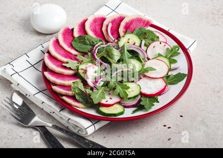 Salat mit Rettich, Gurke, roter Zwiebel und Rucola. Stockfoto