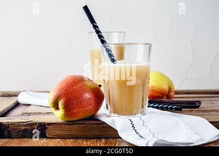 Apfel- und Birnensaft und frisches Obst auf einem Holztisch. Stockfoto