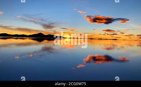 Romantischer Sonnenuntergang über Salinen-Salinen, Salar de Uyuni, Bolivien. Wolkig Reflexion auf dem Salzsee. Abenddämmerung. Flauschige Wolke über Salzwasser. Stockfoto