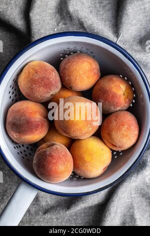Frische reife Bio-Pfirsiche im Sieb. Draufsicht. Stockfoto