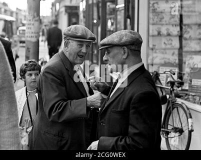 AJAXNETPHOTO. 1968. PORTSMOUTH, ENGLAND. - ZEIGEFINGER - ZWEI ÄLTERE HERREN TAUSCHEN SICH AUF DER LAKE ROAD AUS.FOTO:JONATHAN EASTLAND/AJAX REF:3568108 10 38 Stockfoto