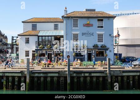 Das Äußere des Bridge Tavern Pub im alten Portsmouth An einem Sommertag sitzen die Kunden auf den Tischen Stockfoto