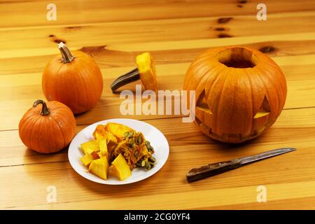 Halloween Schnitzen. Nahaufnahme von Kürbissen oder Jack-o-Laterne und Messer zu Hause. Dekoration und Urlaub Konzept Stockfoto