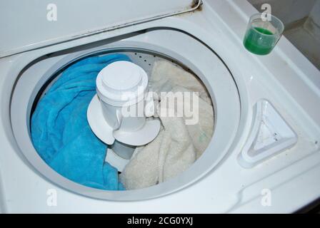 Ladung schmutziger Handtücher in einer Waschmaschine mit Wäsche Reinigungsmittel Stockfoto