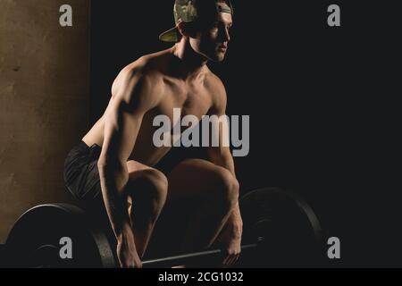Handsome Gewichtheber Vorbereitung für das Training. Geringe Schärfentiefe, selektiver Fokus auf Hände und Staub. Stockfoto