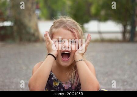 Kleines Mädchen macht Gesichter; Kinder und positive Emotionen Stockfoto